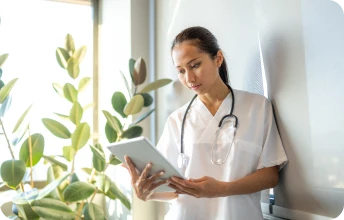 Profissional de saúde utilizando tablet, representando plano Porto Seguro Saúde Linha Pro para empresas que buscam equilíbrio entre custo e cobertura